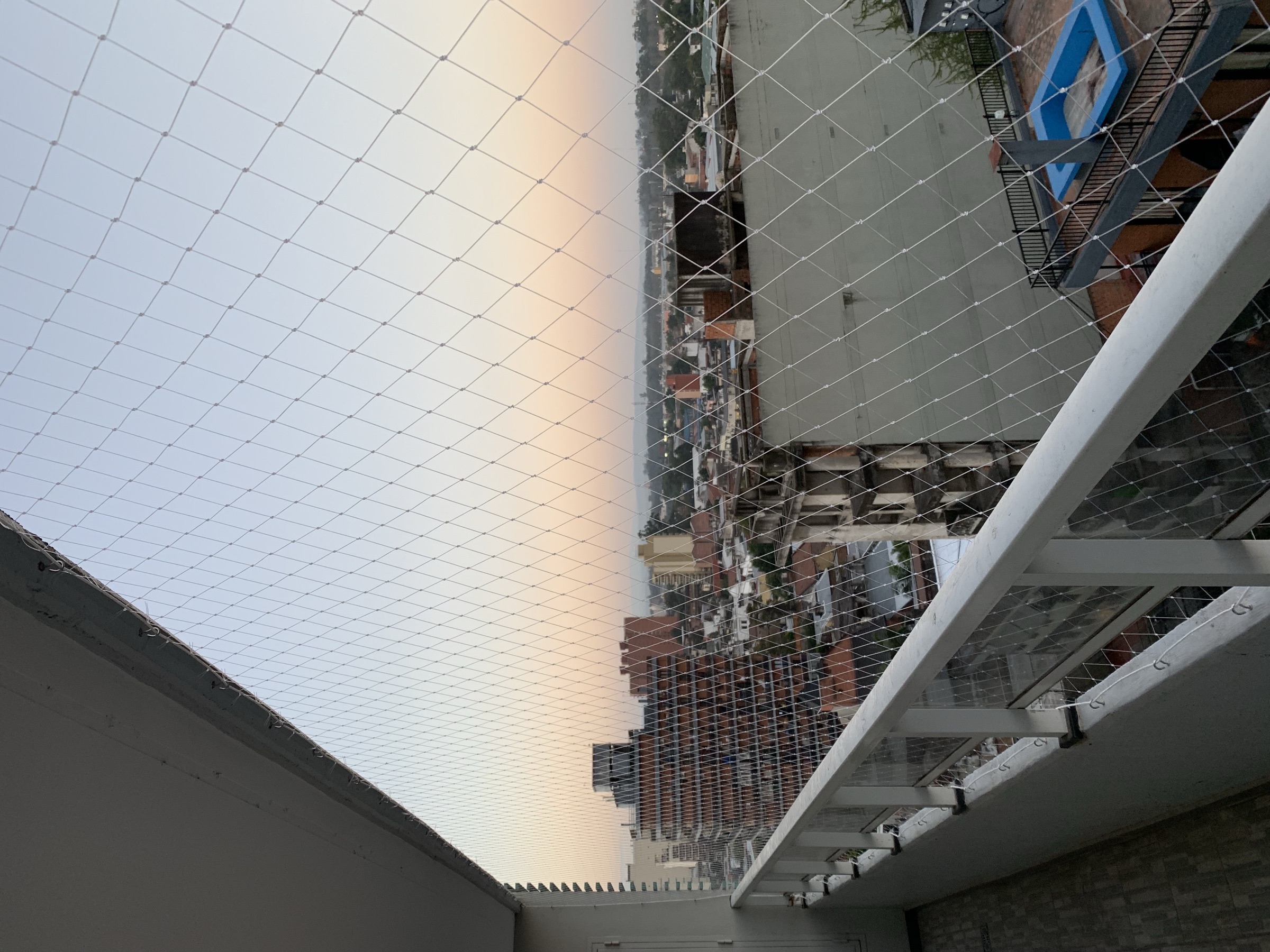 Red de protección transparente con vista a la ciudad al atardecer